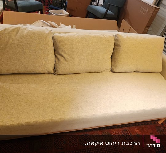 ספה בהירה עם שלושה כריות בסלון
